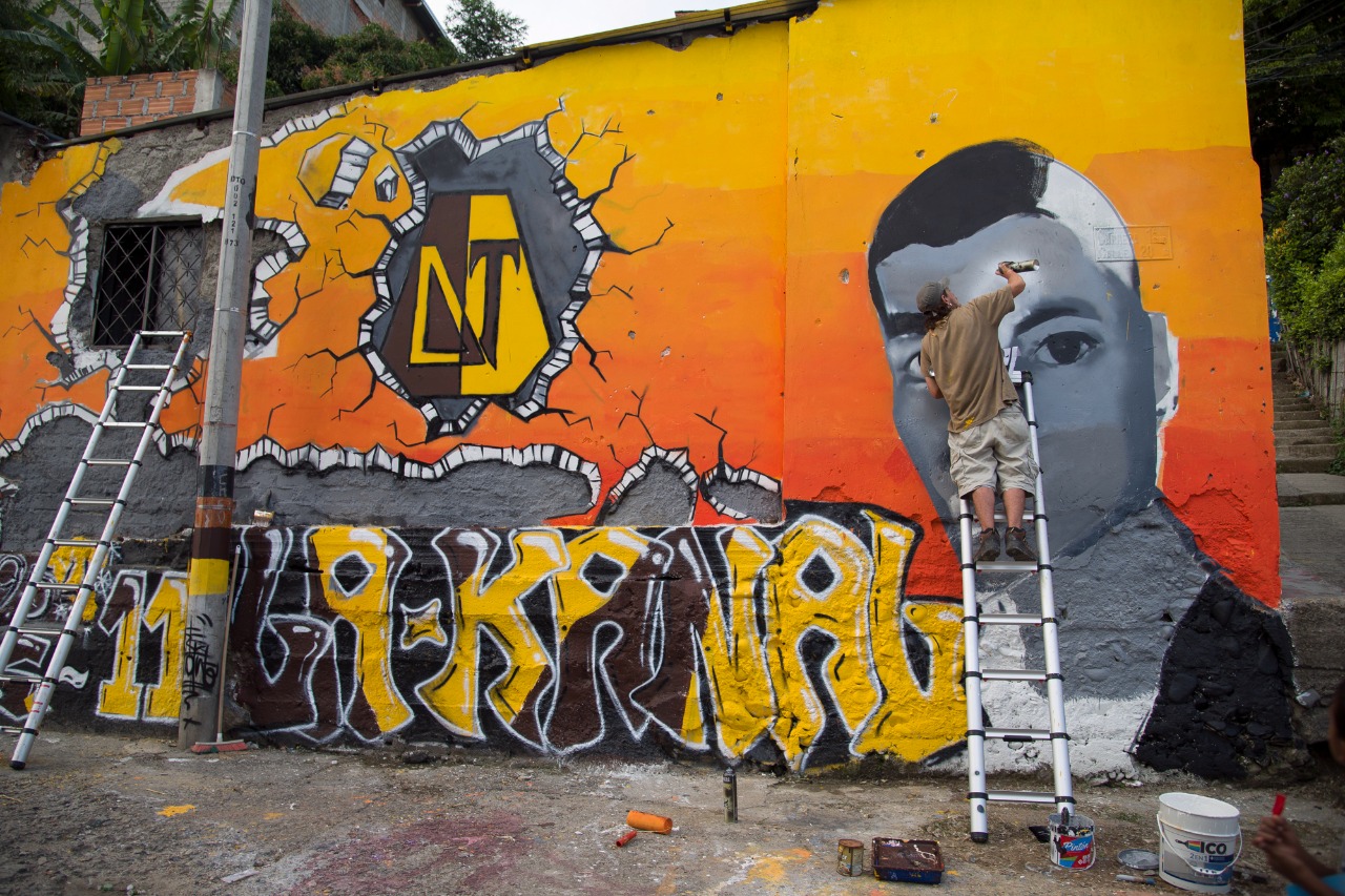 Gestores de paz hinchas del DEPORTES TOLIMA pintan mural en barrio popular de Ibagué